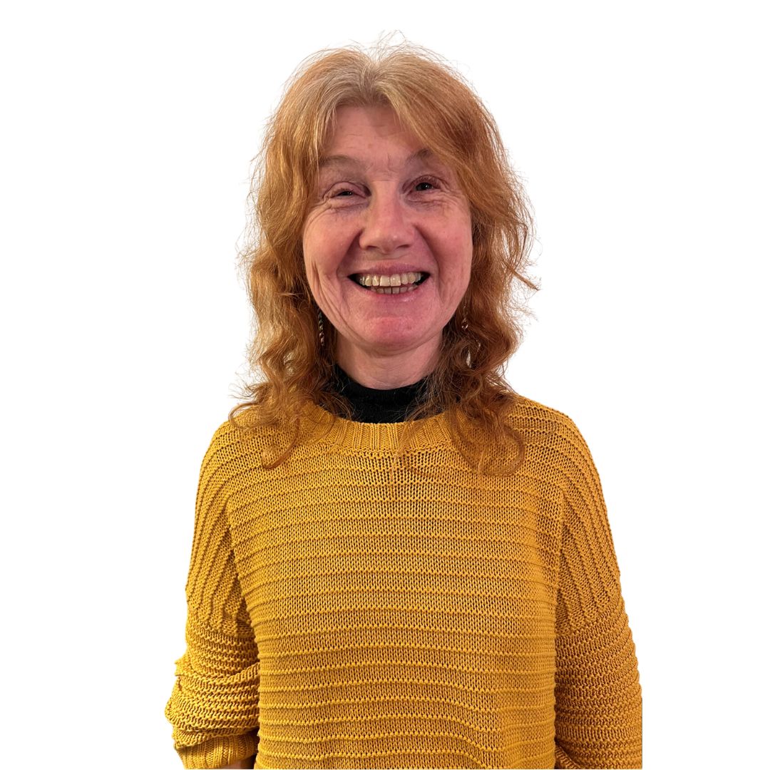 Our FYPO, Vicky, smiles at the camera. She has long, chestnut brown hair and is wearing black framed glasses and a bright red top with white flowers on it.